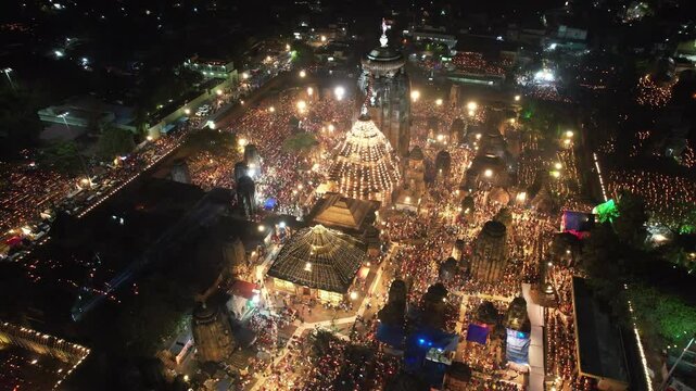Aerial view of Lingaraj Temple in Bhubaneswar, Odisha, illuminated and crowded with devotees celebrating Shivratri in a lively, festive atmosphere at night.