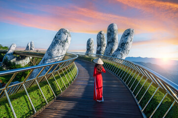 Asian woman wearing Vietnamese cultural red dress with traditional conical hat, Danang City, Vietnam