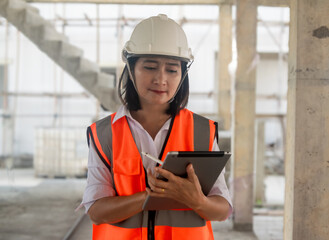 Engineer civil woman wearing uniform safety and hardhat holding digital tablet using stylus pen...