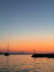 tranquil view of one yacht anchored in water against sunset sky over Adriatic Sea in Dalmatia, Croatia with space for text