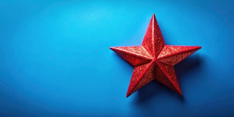 Obraz premium Minimalist Red Christmas Star on Blue Backdrop - Festive Holiday Decoration for Celebrating the Christmas Spirit
