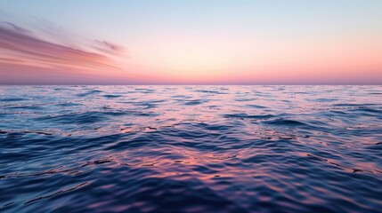 Obraz premium Pink and Blue Ripples Reflecting a Sunset on the Ocean