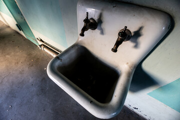 Old Vintage Ceramic Double Tap Sink in Abandoned Building