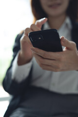 Smiling business woman using cell phone in office. Happy mature professional businesswoman hand holding mobile phone. Social media, internet networking, corporate communication, close up