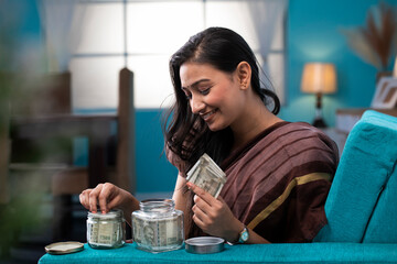 Lady Saving Her Money In Glass Jar
