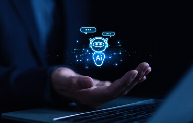 Businessman chatting with AI or artificial intelligence technology. A man uses a laptop computer to...