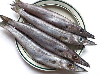 four fresh pacific saury or sanma fish on a plate