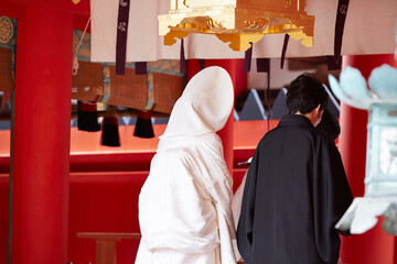 Fototapeta premium Back view of a man and woman getting married at a Japanese shrine