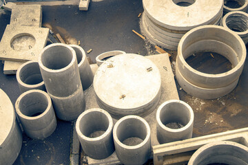 variety of reinforced concrete products, primarily in circular shapes, highlighting their industrial design and structural versatility in construction