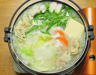 Mizore Nabe, a traditional Japanese home-style nabe dish consisting of grated radish, carrots and other vegetables, chicken, mushrooms, and seafood.