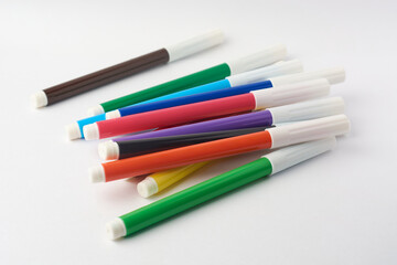 Fototapeta premium colorful felt tip or fiber tip pens scattered isolated white background, tools for vibrant writing, drawing and crafting, mock-up template soft focus