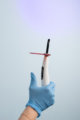 Dental assistant holding a curing light for dental procedures in a modern clinic during an appointment