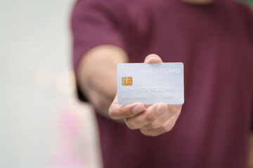 Close-up of a man's hand holding a bank credit card, highlighting online services for lending and access to credit,demonstrating financial convenience and flexibility for secure digital transactions