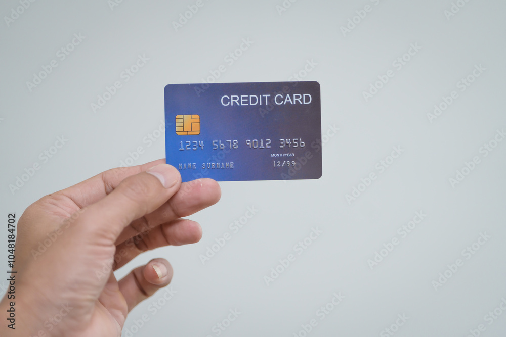 Poster A close-up of a man’s hand holding a bank credit card against a white background, emphasizing secure online payment services and financial convenience for shopping and banking transactions