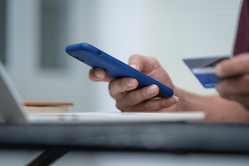 Close-up of a man's hand holding a bank credit card, highlighting online services for lending and access to credit,demonstrating financial convenience and flexibility for secure digital transactions