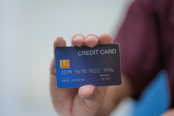 Close-up of a man's hand holding a bank credit card, highlighting online services for lending and access to credit,demonstrating financial convenience and flexibility for secure digital transactions