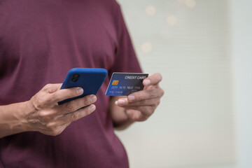 Close-up of a man's hand holding a bank credit card, highlighting online services for lending and access to credit,demonstrating financial convenience and flexibility for secure digital transactions