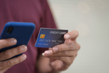 Close-up of a man's hand holding a bank credit card, highlighting online services for lending and access to credit,demonstrating financial convenience and flexibility for secure digital transactions