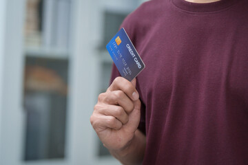 Close-up of a man's hand holding a bank credit card, highlighting online services for lending and...