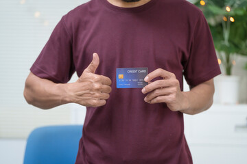 Close-up of a man's hand holding a bank credit card, highlighting online services for lending and access to credit,demonstrating financial convenience and flexibility for secure digital transactions
