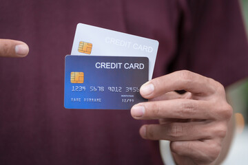 Close-up of a man's hand holding a bank credit card, highlighting online services for lending and...