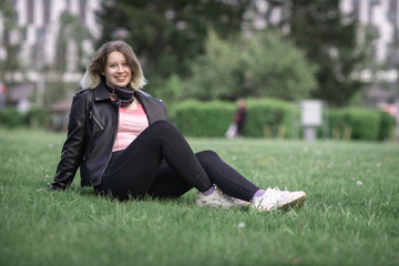 Portrait of a young beautiful girl in a black jacket in an urban environment.