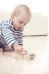 Toddler, boy and learning with building blocks in home with playing, fun and toys for child growth....
