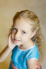 a little girl dressed in a red dress sitting in a room