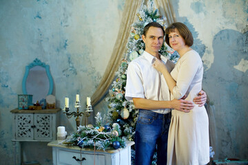 A middle-aged married couple in a New Year or Christmas interior.