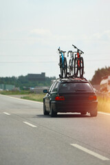 Naklejka premium Car carrying bicycles on a busy highway road