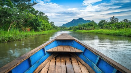 Obraz premium Scenic river boat journey through lush, green surroundings, with muddy water and a bright sky filled with soft clouds