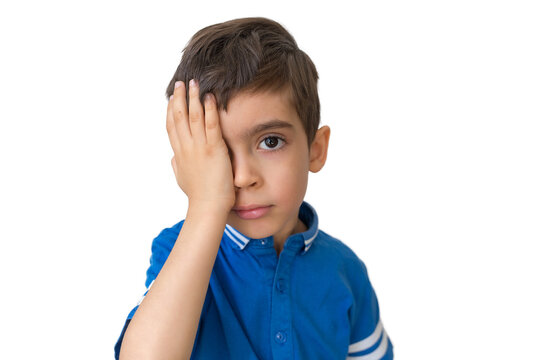 Kid close one eye with hand to check vision on white background. Vision testing concept. Lazy eye, amblyopia, strabismus