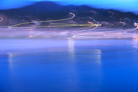 夕暮れの港町と光跡