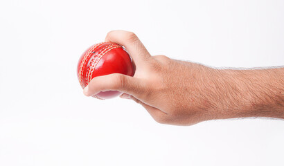 Closeup Photo Of A Male Bowler Firmly Gripping On A Red Test Match Cricket Ball On White Background