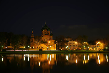 Obraz premium View of the church of the Life-giving Trinity and the Ostankino Estate Museum on the shore of Ostankino pond and their reflection in the water at night. 