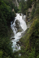 Obraz premium Scenic Waterfall in Lush Forest in the Austrian alps