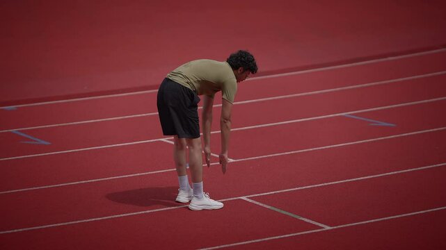 An athlete is seen recovering on the track after completing an intense and challenging sprint