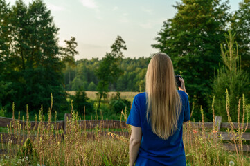 Kobieta blondynka fotografuje i podziwia naturę, dzikie zielone tereny leśne © Paweł Kacperek