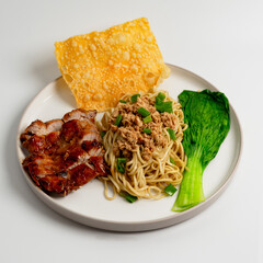Mie ayam teriyaki, Noodles with chicken teriyaki, chicken teriyaki, fried dumpling and vegetables is Indonesia popular food. White background, selective focus.