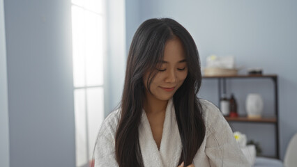 Young chinese woman relaxing at a spa wellness center with a serene expression in an indoor setting