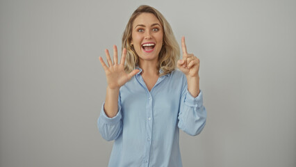 A cheerful young woman gesturing six with fingers on a white isolated background.