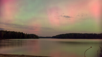 color photo with beautiful northern lights in the sky, northern lights over the lake