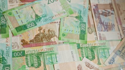 Russian banknotes scattered, highlighting colorful 200 ruble notes prominently within an assortment of various denominations