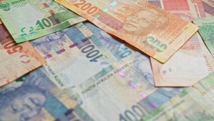 South african banknotes, featuring nelson mandela, scattered closely, showcasing a variety of colorful rands from south africa in a financial theme.