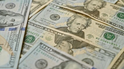 Close-up image of united states dollar banknotes scattered, showcasing various denominations with detailed imagery of historical figures.