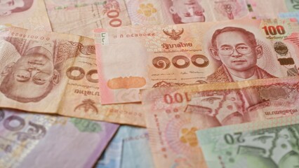 Colorful thai baht banknotes showcasing the currency notes from thailand spread out without any people in the frame, highlighting traditional thai cultural elements and economic themes