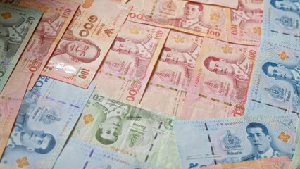 Thai baht banknotes, arranged closely together, feature prominently in this image depicting the currency of thailand.