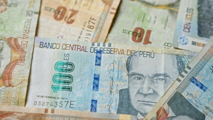 Peruvian banknotes featuring various denominations and designs are spread out in a detailed close-up of peru's legal tender, emphasizing the banco central de reserva del perÃº.