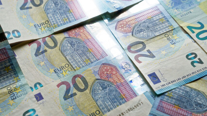 Euro currency notes arranged closely together, showcasing multiple twenty euro bills in a detailed close-up image highlighting european currency design.