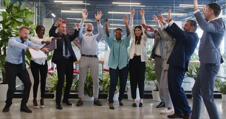 Group of happy smiling multiracial business people having fun at corporate training, raising their hands up during team building business event and creating friendly team. Corporate culture concept.